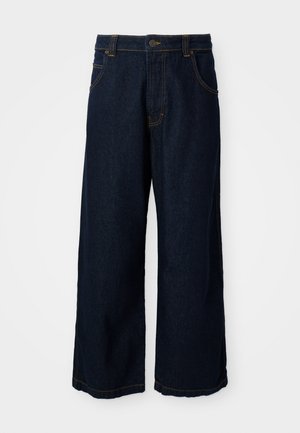 Sötétkék farmer széles szárú nadrág, arany öltésekkel, gombos záródással és négy zsebbel. Az alja enyhén koptatott.