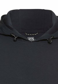 Zwarte hoodie met verstelbare koordjes en een zichtbaar Camel Active merkembleem binnenin de kraag.