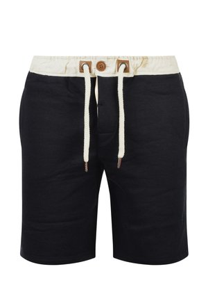 Melnas šortus, izgatavotus no mīksta auduma, ar krēmkrāsas jostu, kaklasaiti ar brūniem akcentiem un taisnu griezumu.