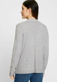 Graue Strickjacke mit umgeschlagenem Kragen, langen Ärmeln und geradem Schnitt. Verfügt über strukturierter Stoff sowie gerippte Bündchen und Saum.