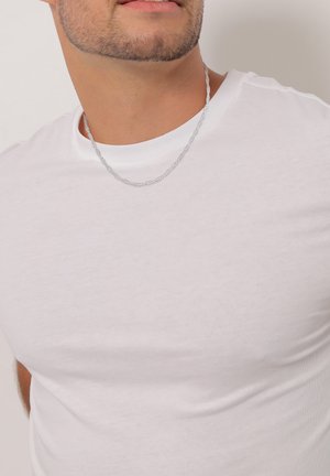 Weißes Baumwoll-T-Shirt mit Rundhalsausschnitt, taillierter Form und glatter Textur, kombiniert mit einer dünnen silbernen Kettenhalskette.