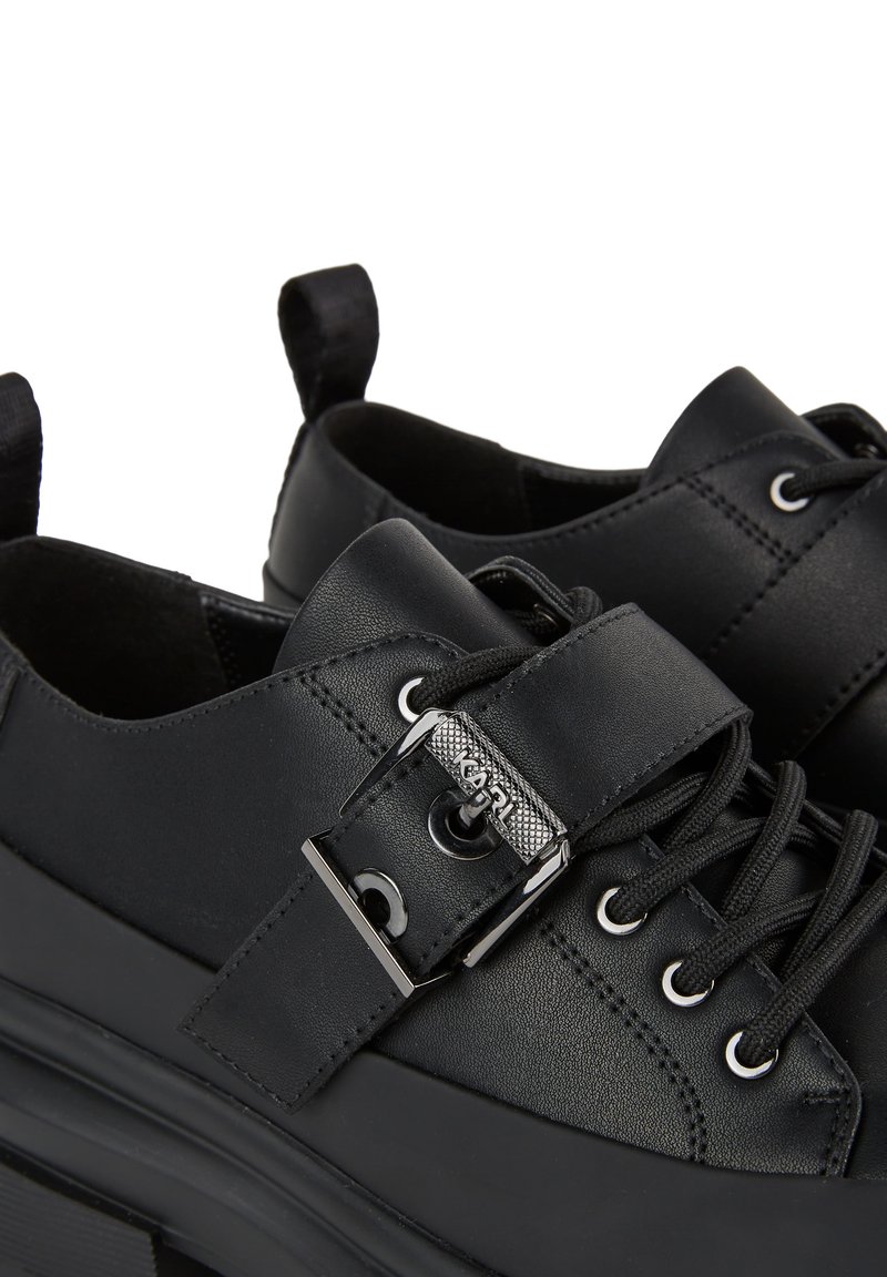 Chaussures en cuir noir avec un bout arrondi, dotées d'un détail à boucle, de lacets et d'une semelle épaisse pour plus de hauteur.