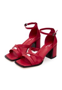 Rode sandalen met hoge hakken, vierkante neuzen, meerdere banden en enkelgespen; gestructureerd materiaal; robuuste zwarte hak voegt contrast toe.