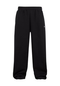 Melnas sporta bikses, kas izgatavotas no mīksta auduma ar elastīgu jostu un uzmavām. Tām ir vienkāršs dizains, bez redzamām rakstu vai detaļām.