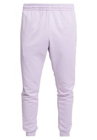 Ljust lila sweatpants i mjukt tyg, med elastisk midja, muddar vid anklarna och en liten logodetalj på vänster lår.