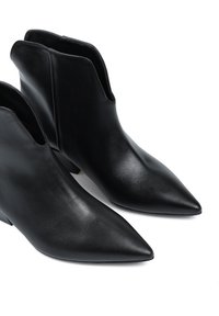 Czarne skórzane botki za kostkę z ostrym noskiem, eleganckim designem, niskim obcasem w formie stosika oraz otwartymi krawędziami dla łatwego zakładania. Gładka tekstura.