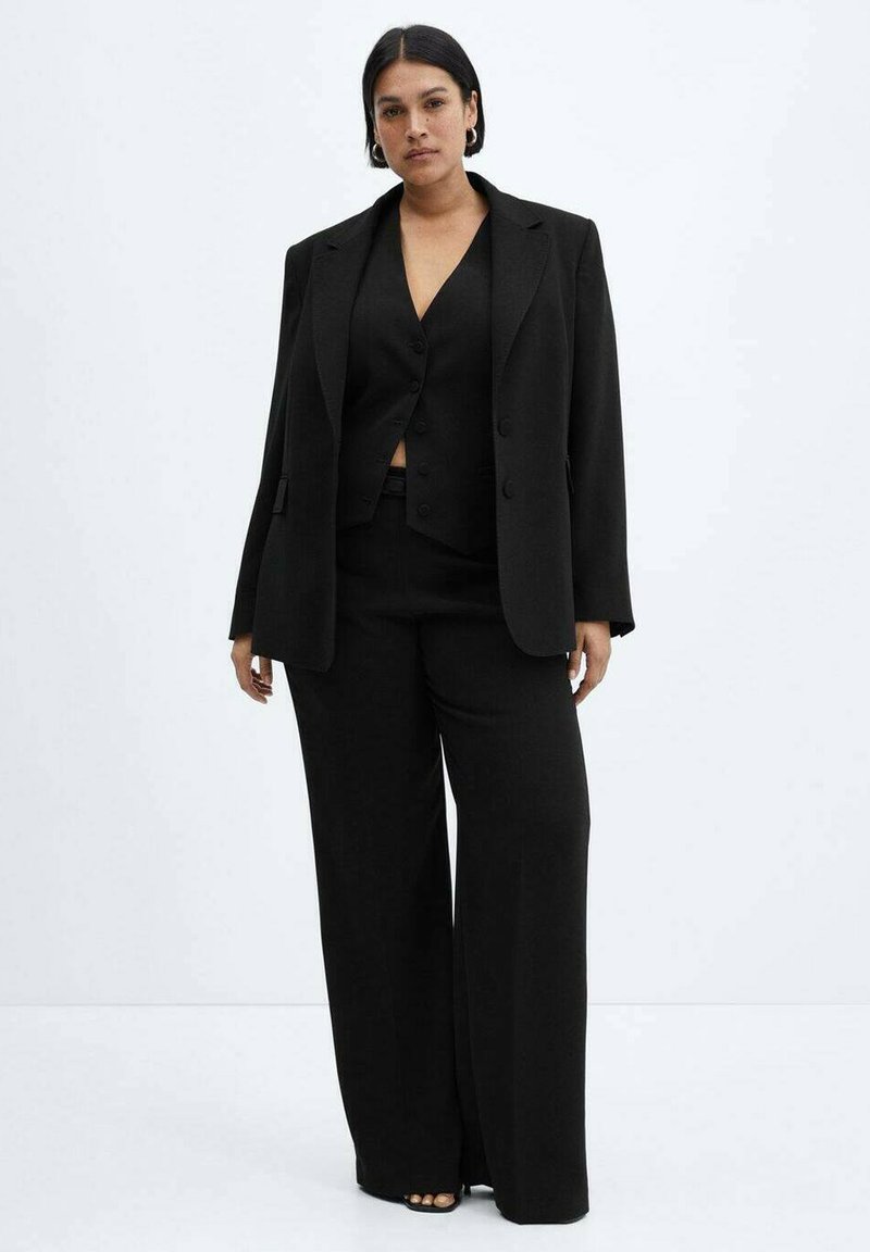 Schwarzer dreiteiliger Anzug mit einem maßgeschneiderten Blazer, einer taillierten Weste und weiten Hosen. Glattes Gewebe mit minimalistischem Design und ohne Muster.