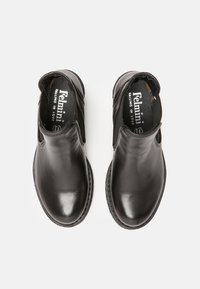 Bottines en cuir noir avec un bout rond, des panneaux élastiques sur les côtés et une semelle en caoutchouc texturé. Intérieur doublé en tissu.