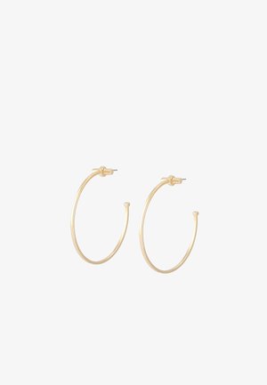 De petites boucles d'oreilles en or fin avec fermoirs à tige, présentées côte à côte sur un fond blanc.