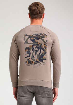 Beige sweatshirt with a textured back graphic in dark blue, green, and orange abstract patterns, featuring a curved hem and ribbed cuffs.