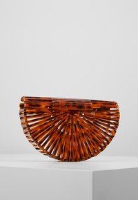 Brun sköldpaddsdesign handväska med en halvcirkelform, prydd med vertikala spatlar och ett klart toppstängning. Slät textur och modern design.