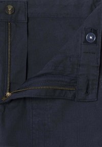 Námornícka modrá tkanina s čiastočne rozopnutým mosadzným zipsom, hnedým gombíkom a prišitým gombíkovým otvorom na páse odevu.