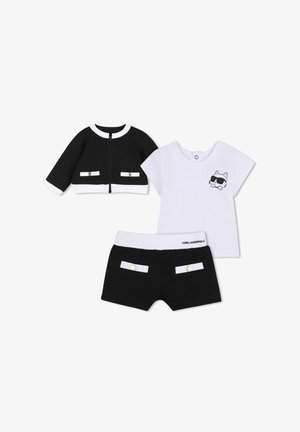 Completo per bambini in bianco e nero con giacca a maniche lunghe, maglietta bianca a maniche corte con disegno di un gatto con occhiali da sole e pantaloncini neri.