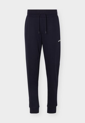 Pantaloni jogger blu navy con vita elasticizzata e coulisse, gambe rastremate, polsini alle caviglie e piccolo logo bianco sulla coscia destra.