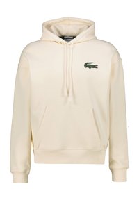 Felpa con cappuccio color crema realizzata in morbido tessuto. Presenta una tasca a marsupio, polsini a coste e un logo di coccodrillo ricamato in verde.