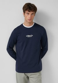 Marinefarbener Langarm-T-Shirt aus Baumwolle, mit Rundhalsausschnitt und dem weißen "s.Oliver Co." Logo auf der Brust. Weicher Stoff, lässiges Design.