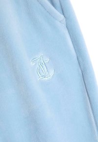 Šviesiai mėlyna suknelė su minkšta medžiaga, su siuvinėtu logotipu kontrastinga siūle. Yra priekinė kišenė ir struktūrizuoti rankogaliai.