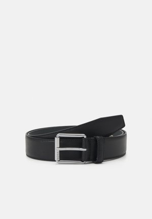 Ceinture en cuir noir avec une finition texturée, dotée d'une boucle en métal argenté et d'une seule boucle en cuir, conçue pour un ajustement réglable.