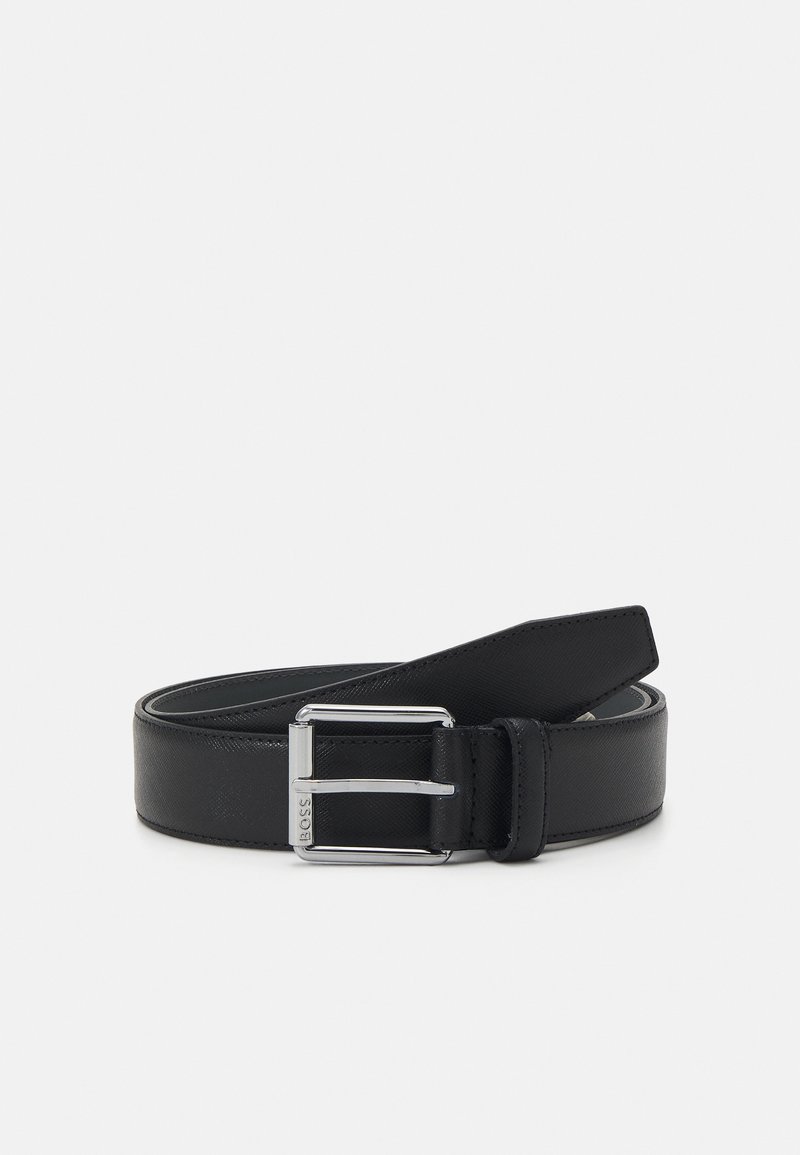 Ceinture en cuir noir avec une finition texturée, dotée d'une boucle en métal argenté et d'une seule boucle en cuir, conçue pour un ajustement réglable.