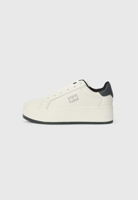 Witte sneaker met een licht verhoogd platform, gladde textuur, zwarte accenten op de hiel en een logo op de zijkant.