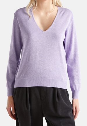 Maglione lavanda a scollo a V con maniche lunghe, realizzato in un tessuto luccicante, con dettagli a costine sull'orlo e sui polsini, abbinato a pantaloni neri.