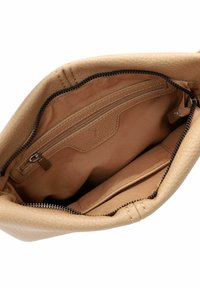 Wnętrze torebki skórzanej w kolorze brązowym z zamykaną na zamek kieszonką, gładką teksturą i beżową podszewką. Posiada czarny zamek błyskawiczny oraz detale przeszycia.