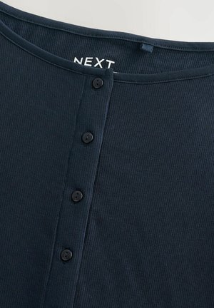 Marineblaues, geripptes Stoffoberteil mit rundem Ausschnitt, fünf schwarzen Knöpfen vorne und einem dezenten Markenetikett mit der Aufschrift "NEXT" am Kragen.