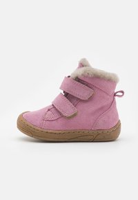 Bottine rose en suede avec deux sangles Velcro réglables, doublure en fausse fourrure au col et une semelle en caoutchouc texturé. Design à bout rond.