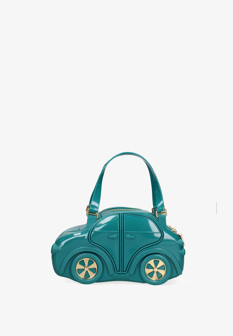 Türkisfarbene Handtasche in Form eines kompakten Autos mit goldakzentuierten Rädern, oberen Reißverschluss und zwei Schulterriemen vor weißem Hintergrund.