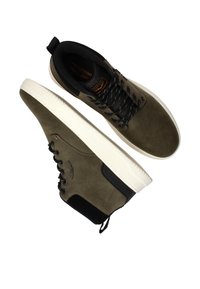 Olijfgroene suede hoge sneakers met zwarte accenten, een witte rubberen zool en zwarte veters. Kenmerkt zich door een logodetail aan de zijkant en een trekband.