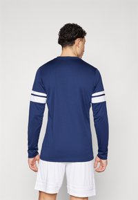 Marineblauw sportshirt met lange mouwen en witte strepen op de mouwen, gemaakt van soepel, lichtgewicht materiaal, met een ronde hals en een standaard pasvorm.