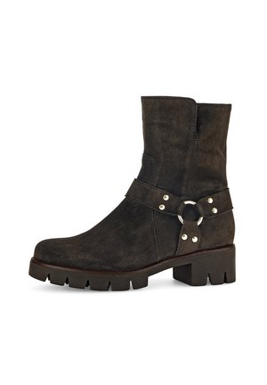 Dark brown suede ankle boots with a flat rubber sole, featuring a strap with silver hardware and a circular accent near the ankle.