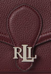 Burgundy leather handbag with textured surface, featuring a prominent silver "RLL" hardware logo and contrasting stitching.