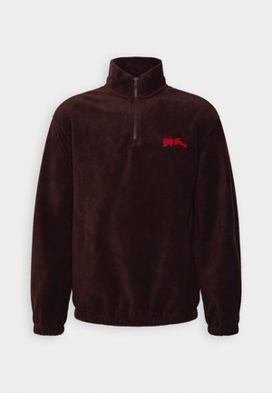 Dark brown fleece pullover with quarter-zip, high collar, elastic cuffs, and red "Bdg Jeans" embroidery on the left chest.
