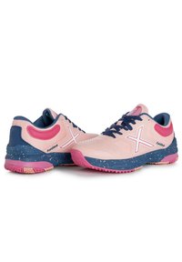 Scarpe da ginnastica rosa chiaro con un accento blu, tomaia in mesh testurizzato, suola maculata e logo e lacci bianchi a contrasto.