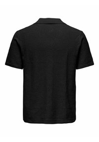 Polo noir à manches courtes avec un subtil motif texturé en forme de vague, vu de dos sur fond blanc.