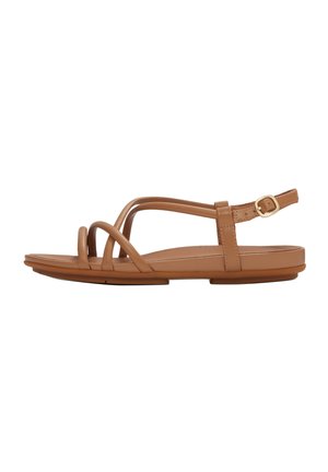 Bruine platte sandaal met dunne leren bandjes en een verstelbare enkelriem op een witte achtergrond.