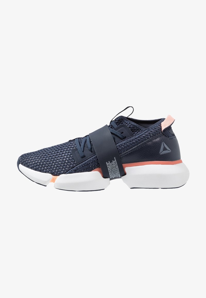 Chaussure de sport en maille bleu marine avec large bride noire, semelle blanche segmentée, accents corail et logo Reebok au talon.