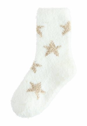 Calcetín blanco difuso con patrones de estrellas en un tono beige claro; textura suave, punta redondeada y diseño de longitud media hasta la pantorrilla.