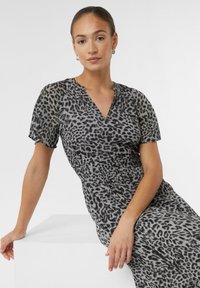 Grau und schwarz gepunktetes Leopardenkleid mit kurzen Ärmeln, V-Ausschnitt und gerafftem Taillenbereich. Weicher Stoff mit fließendem Design.