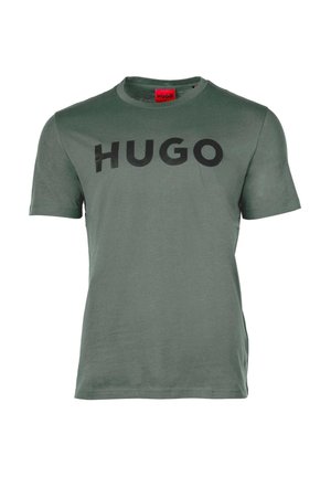 Green short-sleeve crewneck T-shirt with black "HUGO" text centered on the chest and a red tag inside the collar.