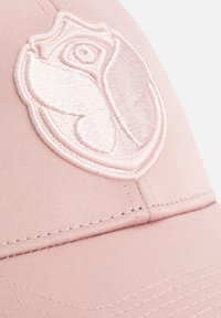 Roze pet met een geborduurd rozenontwerp. De stof is glad met zichtbare stiksels langs de rand en de kroon.