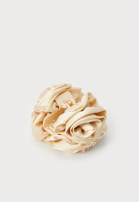 Elástico de cabelo em cetim bege em forma de flor, com textura suave e macia e pétalas em camadas. Fecho seguro para prender o cabelo.