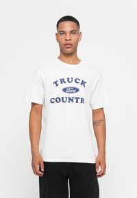 Hvit bomulls t-skjorte med blå tekst "TRUCK FORD COUNTRY". Korte ermer, rund hals og avslappet passform. Enkelt design uten mønstre.