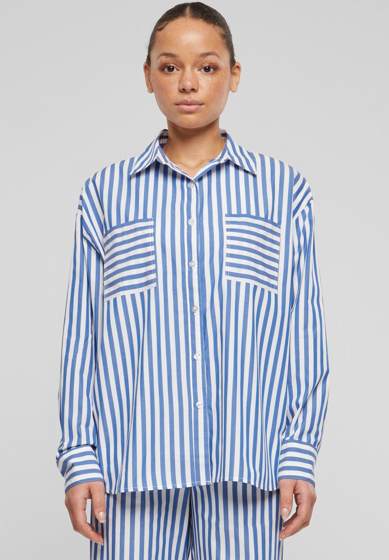 Camicia a maniche lunghe a righe blu e bianche con due tasche, colletto e vestibilità comoda. Tessuto morbido.