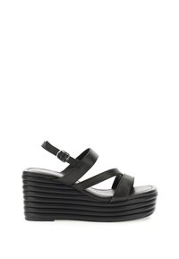 Schwarze Keilsandalen mit mehreren überkreuzten Riemen, einem schmalen Knöchelriemchen mit Schnalle und einer geriffelten Plateausohle.