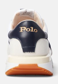 Sneaker navy e bianco con tallone in pelle, branding "Polo" dorato, suola in gomma texturizzata e colletto imbottito per il comfort.