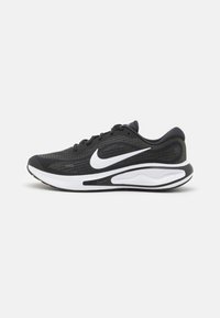 Scarpe da corsa Nike nere e verde scuro con logo swoosh bianco e suola imbottita bianca, mostrate in profilo laterale su uno sfondo semplice.