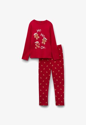 Set di pigiama rosso composto da una maglia a maniche lunghe con stampa di omini di pan di zenzero e testo, abbinata a pantaloni decorati con piccoli omini di pan di zenzero.