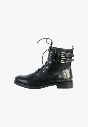Botte de cheville en cuir noir avec un laçage à l'avant, deux sangles à boucles argentées et un détail texturé sur le talon et la sangle.